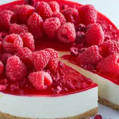 En läcker cheesecake i glas, toppad med färska hallon och hallonspegel. Perfekt för en somrig fika.