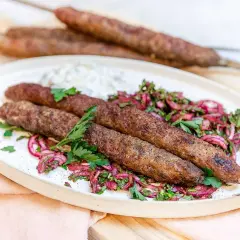 Adana kebab recept: saftiga köttfärsspett med rödlökssallad och en klick sås. Perfekt för grillen!