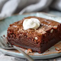 En saftig chokladbrownie med hasselnötter, toppad med vispgrädde. Perfekt för ett brownie recept!