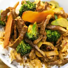 En skål med ris toppad med saftig biff teriyaki, krispig broccoli och söt paprika. En härlig asiatisk rätt.